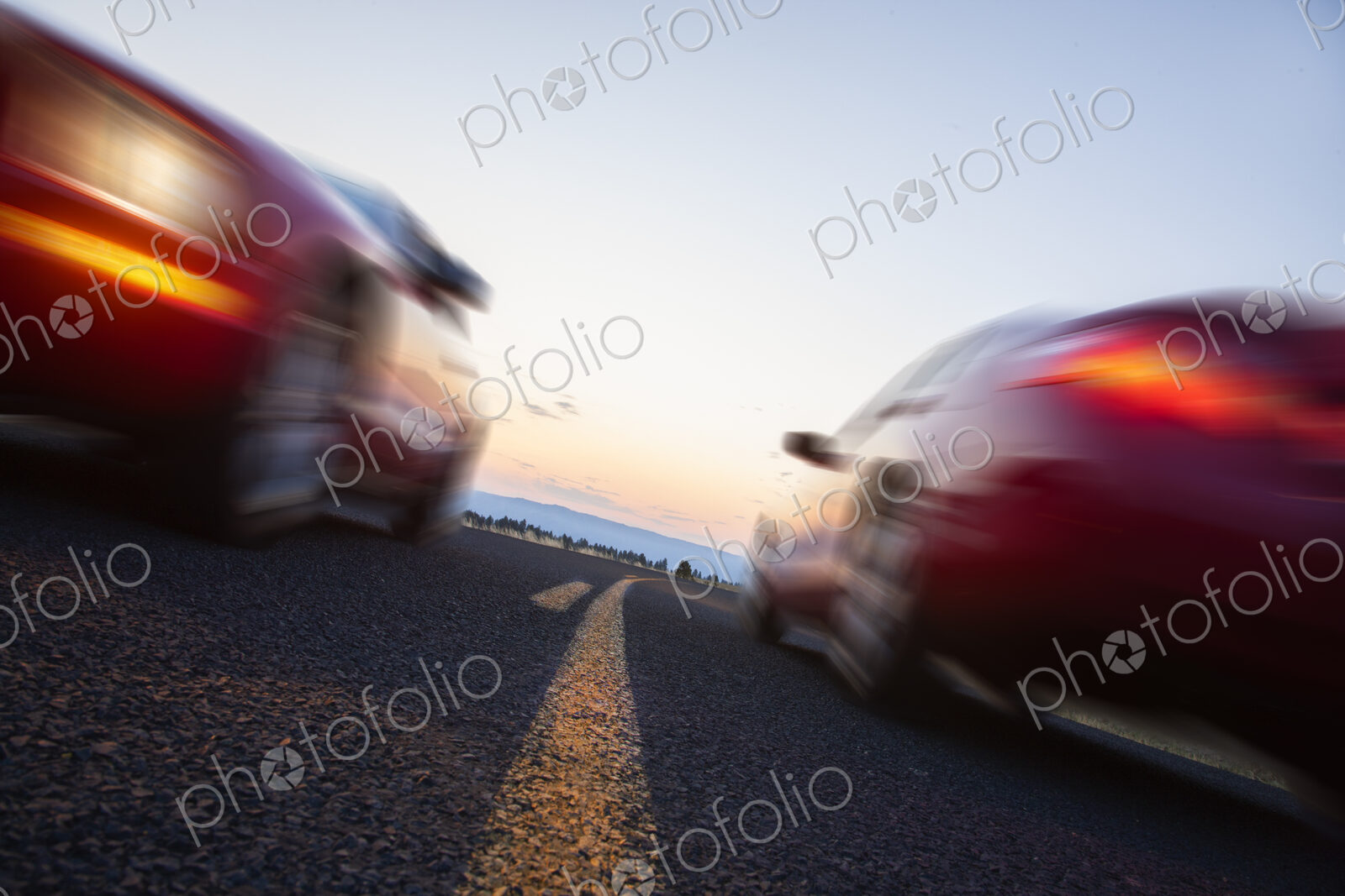 A low angle view of two cars blurred and passing each other going opposite ways on a…