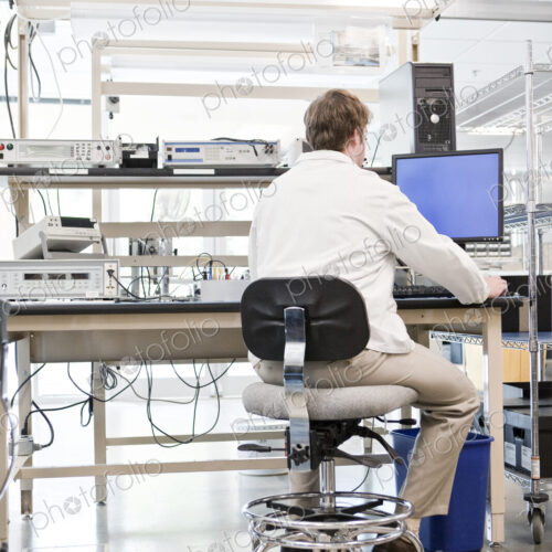 A male caucasian technician greeting a female coworker in a technical research and… A male caucasian technician greeting a female coworker in a technical research and…