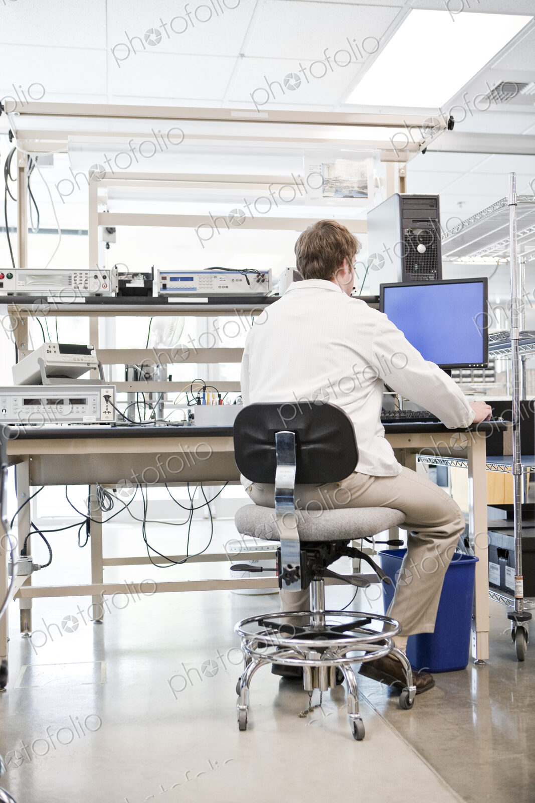 A male caucasian technician greeting a female coworker in a technical research and…