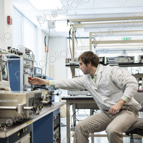 A male caucasian technician sitting at a workbench at a technical research and… A male caucasian technician sitting at a workbench at a technical research and…