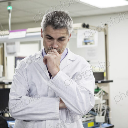 A male caucasian technician working over a problem in a technical research and…