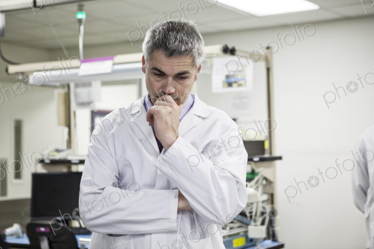 A male caucasian technician working over a problem in a technical research and…