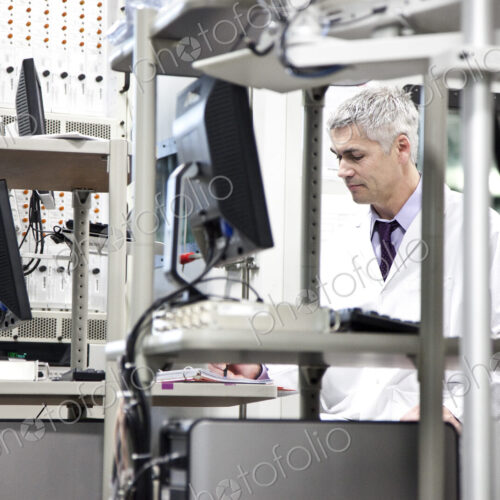 A male caucasian technician working over a problem in a technical research and…