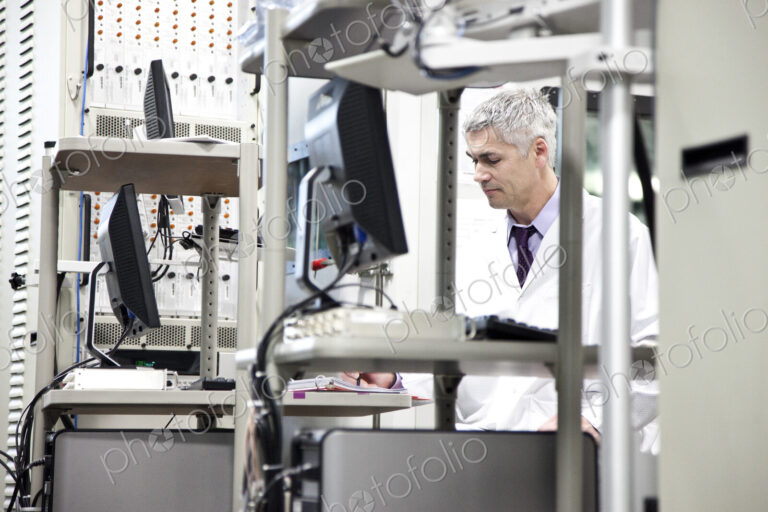A male caucasian technician working over a problem in a technical research and…