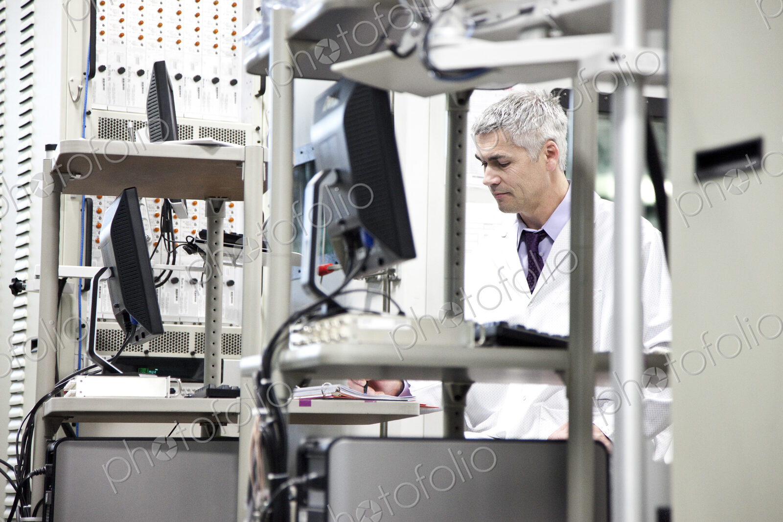A male caucasian technician working over a problem in a technical research and…