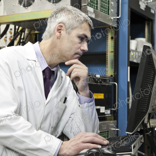 A male caucasian technician working over a problem in a technical research and…