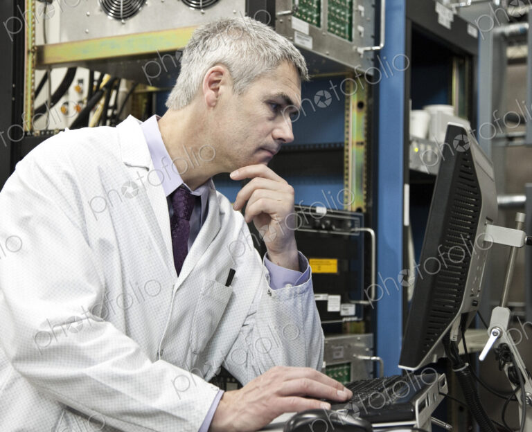 A male caucasian technician working over a problem in a technical research and…