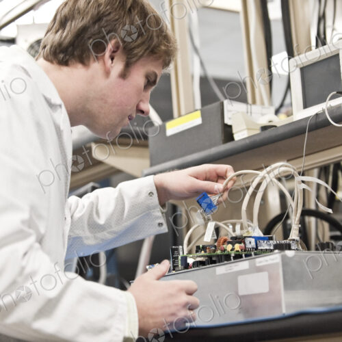 A male caucasian technician working over a problem r in a technical research and…