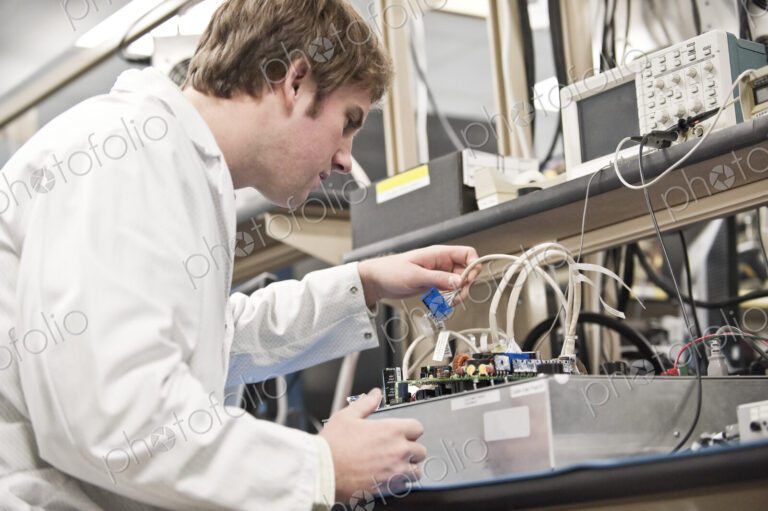 A male caucasian technician working over a problem r in a technical research and…
