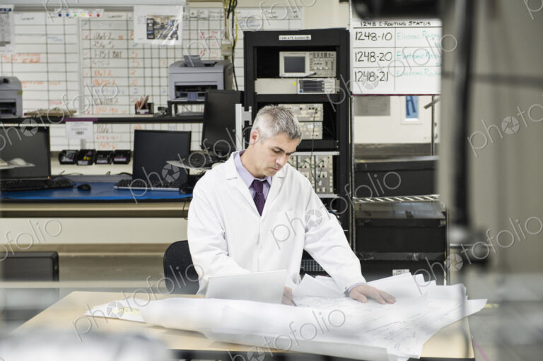 A male caucasian technician working over a problem r in a technical research and…