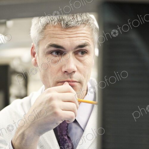 A male caucasian technician working over a problem r in a technical research and…
