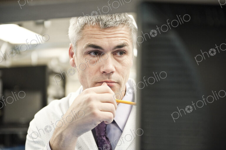 A male caucasian technician working over a problem r in a technical research and…