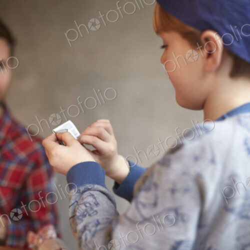 A man and a child seated at a kitchen table sharing a cracker joke. A man and a child seated at a kitchen table sharing a cracker joke.