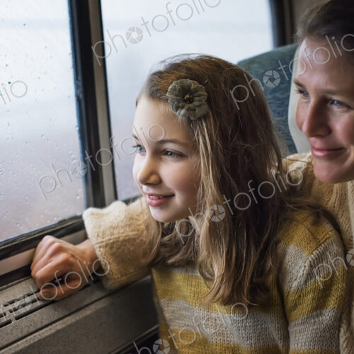 A man and a young girl sitting beside the window in a train carriage looking out at… A man and a young girl sitting beside the window in a train carriage looking out at…
