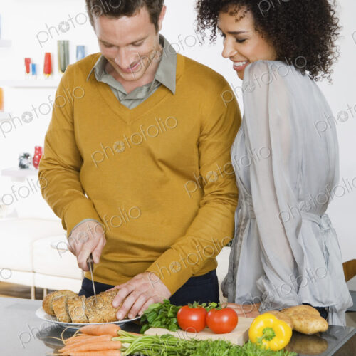 A man and woman, a couple in a kitchen preparing fresh vegetables. A man and woman, a couple in a kitchen preparing fresh vegetables.