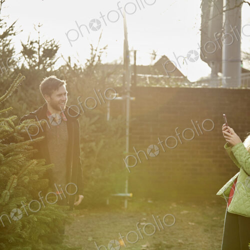 A man and woman choosing a traditional pine tree, Christmas tree A man and woman choosing a traditional pine tree, Christmas tree