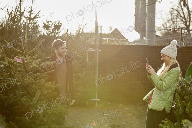 A man and woman choosing a traditional pine tree, Christmas tree