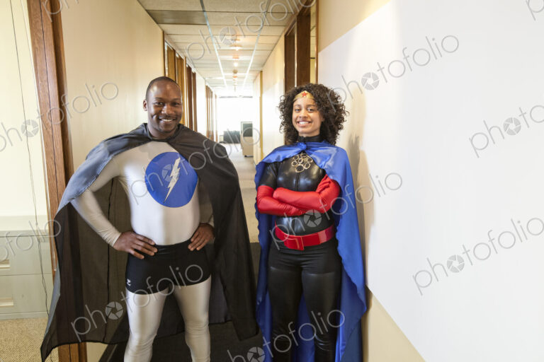 A man and woman team of black office super hero's standing in a hallway of thier office.