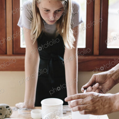 A man and young woman making pastry in a kitchen.