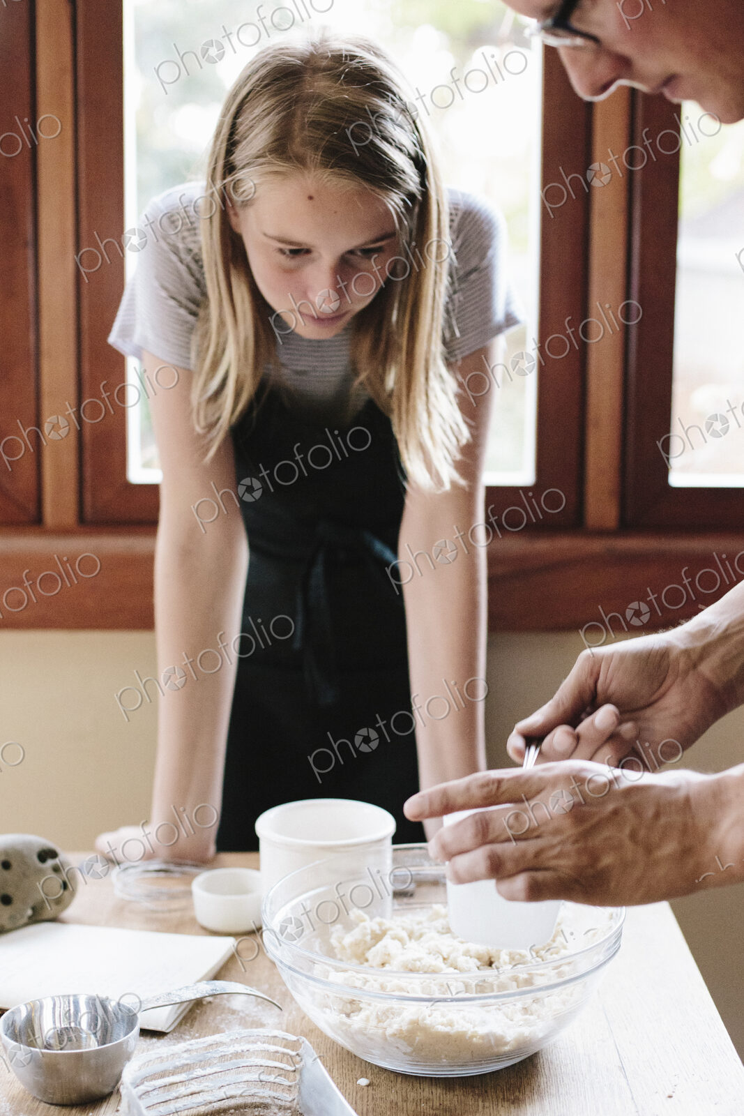 A man and young woman making pastry in a kitchen.