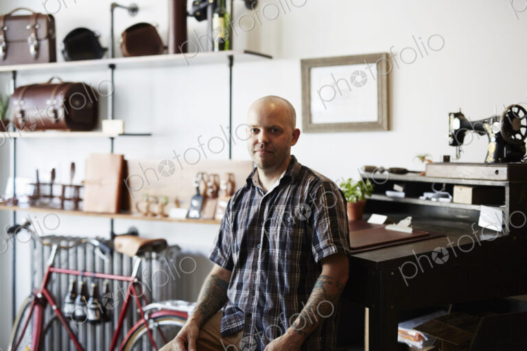 A man, craftsman and leather worker in a leather workshop.