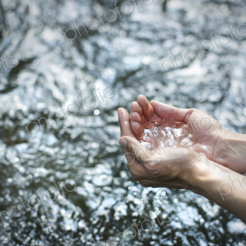 A man cupping his hands and scooping up clear water from a river. A man cupping his hands and scooping up clear water from a river.