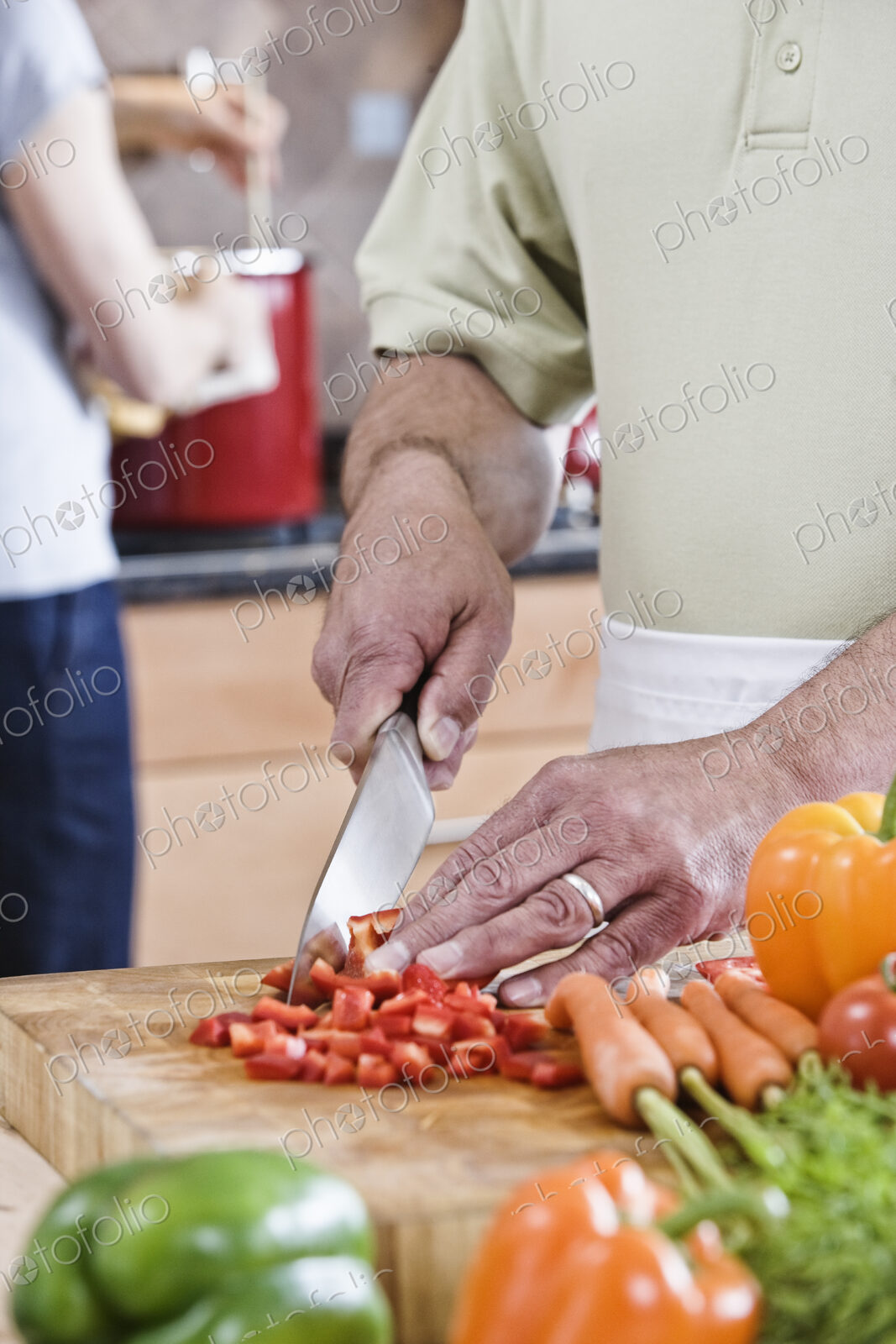 A man cutting vegetables preparing to cook dinner in a kitchen.