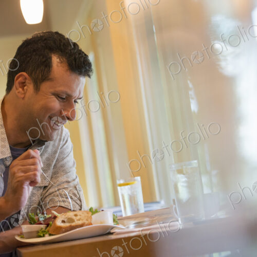 A man eating a snack in a cafe.