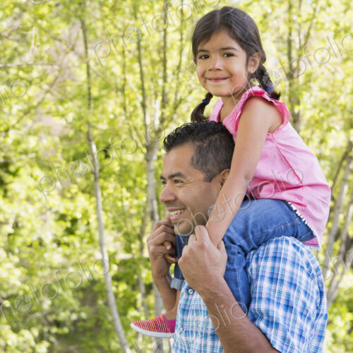 A man giving his daughter a piggyback ride on his shoulders. A man giving his daughter a piggyback ride on his shoulders.