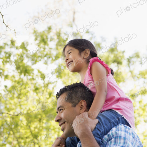 A man giving his daughter a piggyback ride on his shoulders. A man giving his daughter a piggyback ride on his shoulders.