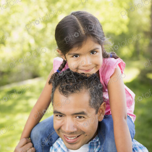 A man giving his daughter a piggyback ride on his shoulders. A man giving his daughter a piggyback ride on his shoulders.
