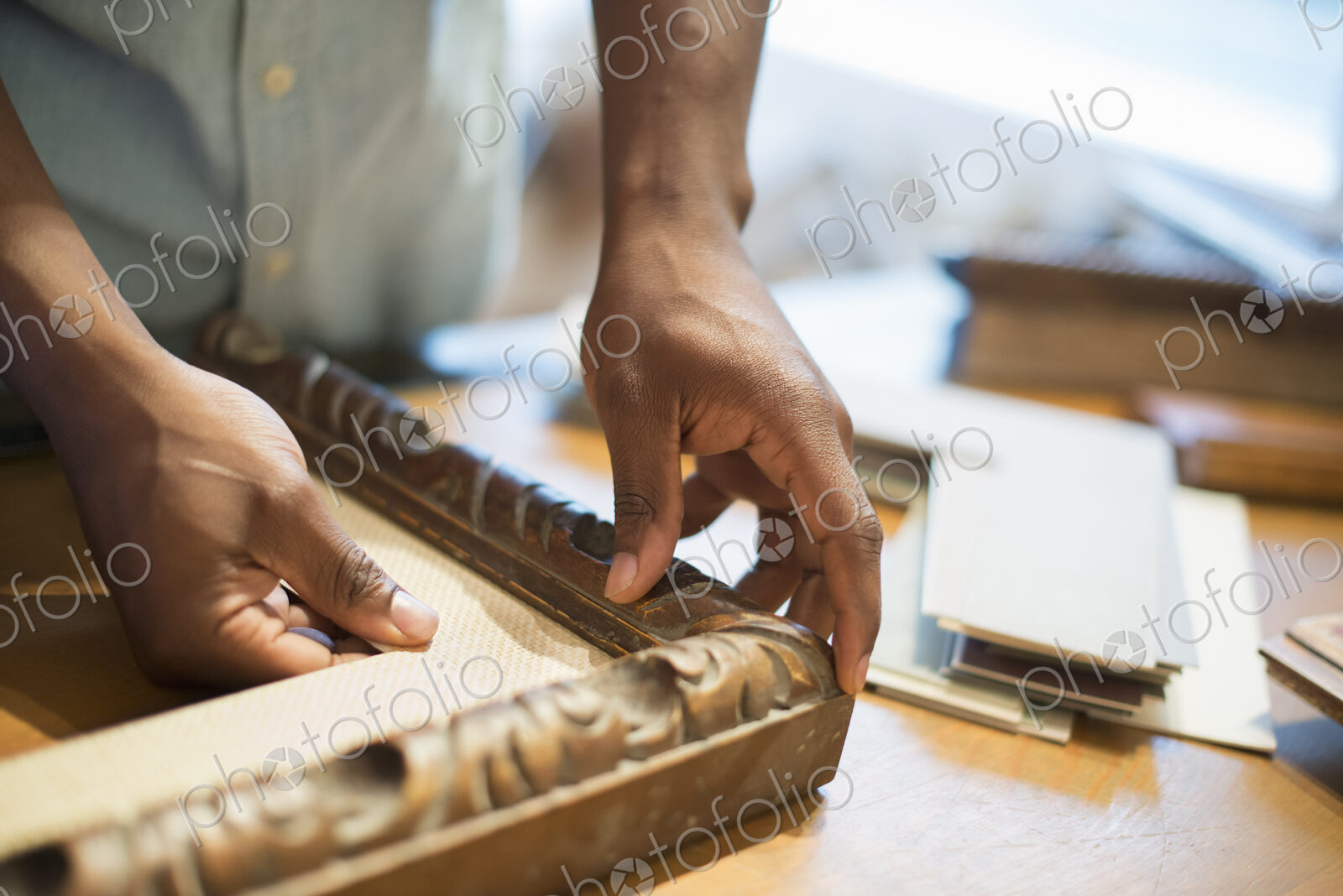 A man holding samples of picture mounts and frames, selecting colour and style.