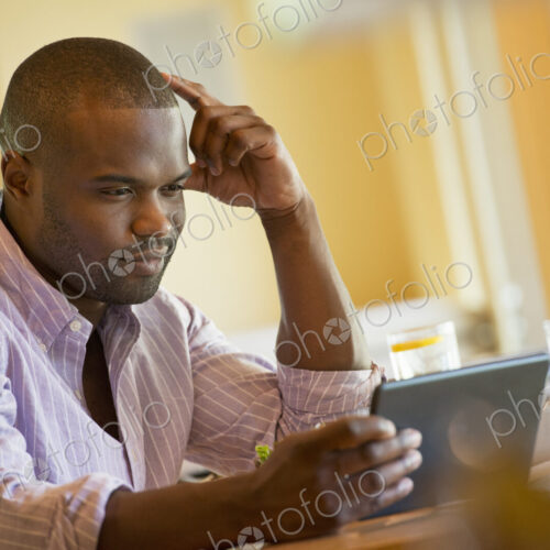A man in a cafe, using a digital tablet. A man in a cafe, using a digital tablet.