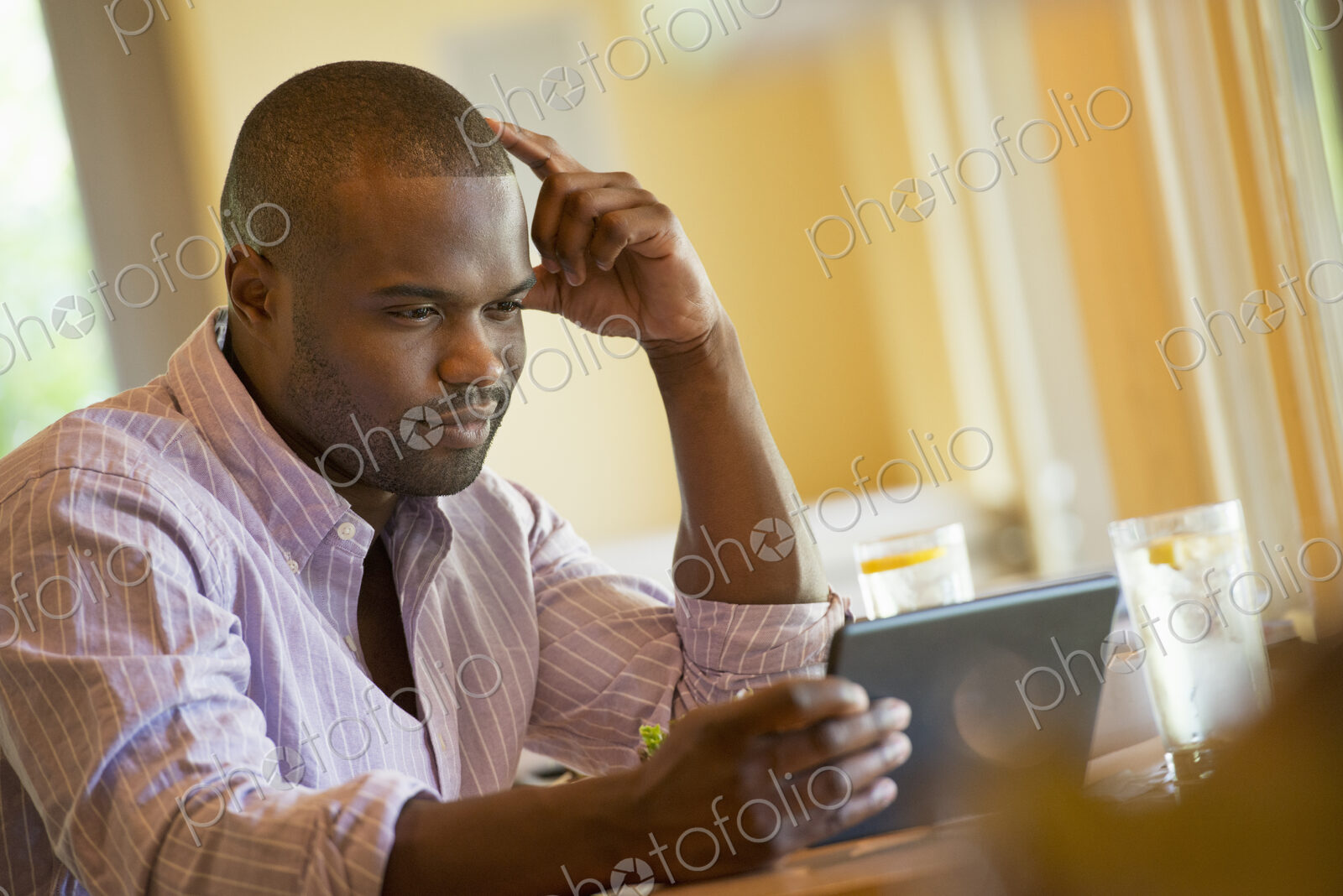 A man in a cafe, using a digital tablet.