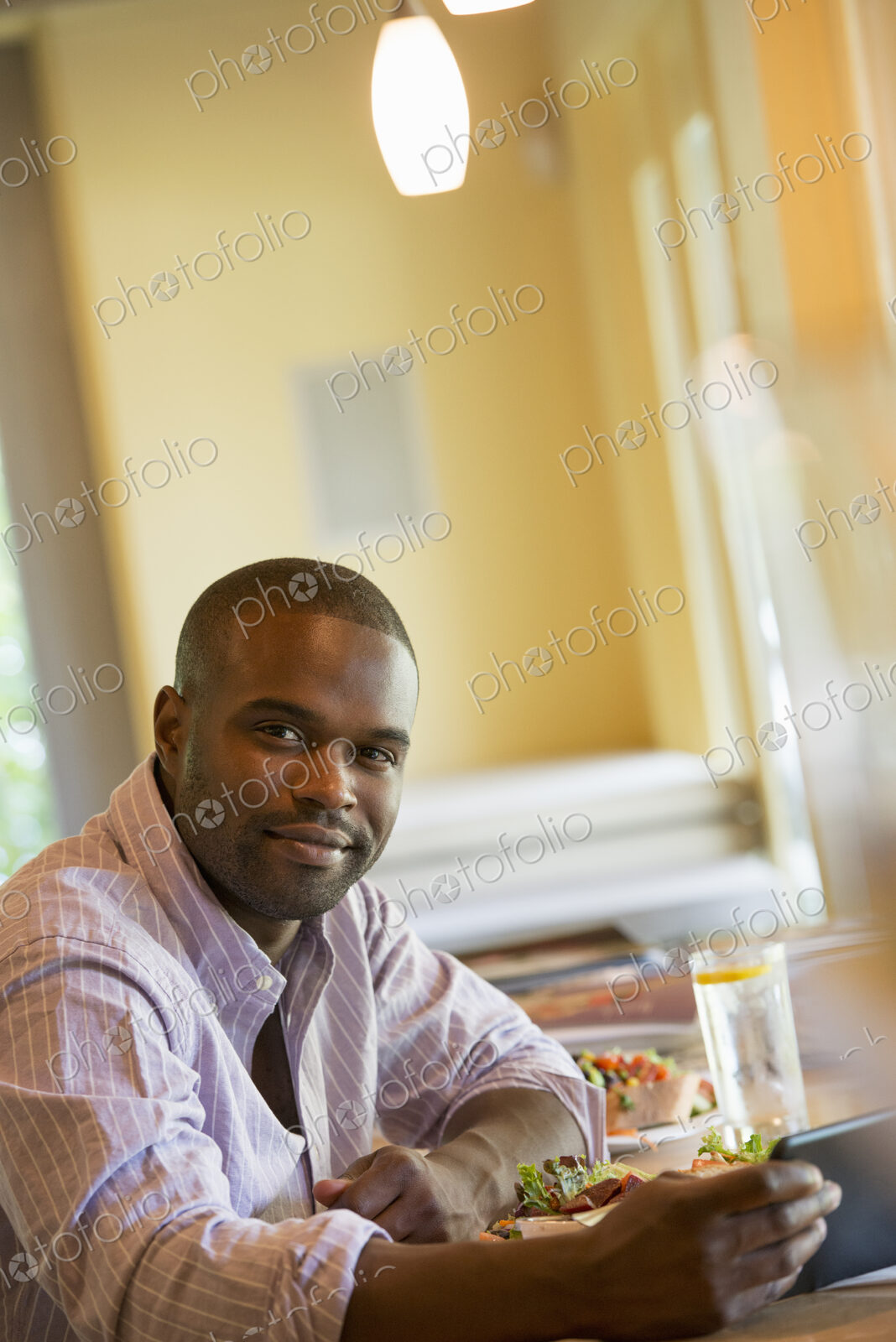 A man in a cafe, using a digital tablet.