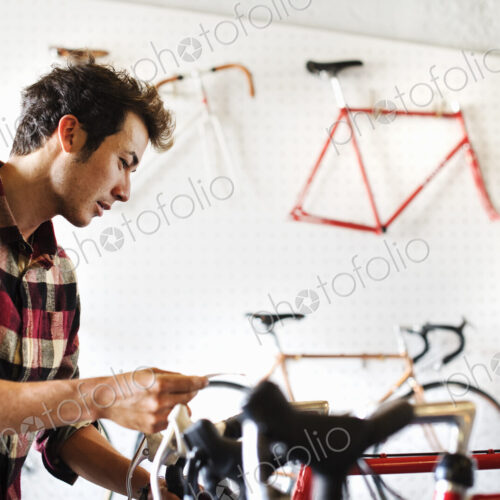 A man in a cycle shop, reading the price label on a bike. A man in a cycle shop, reading the price label on a bike.