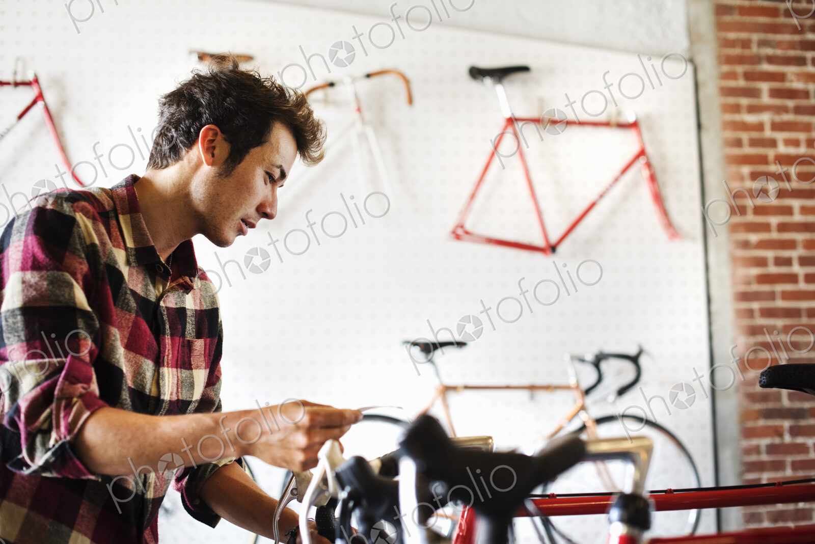 A man in a cycle shop, reading the price label on a bike.