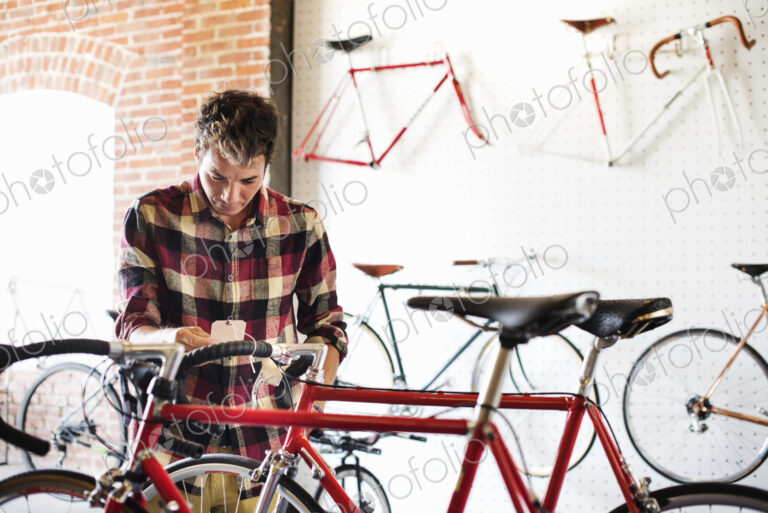 A man in a cycle shop, reading the price label on a bike.