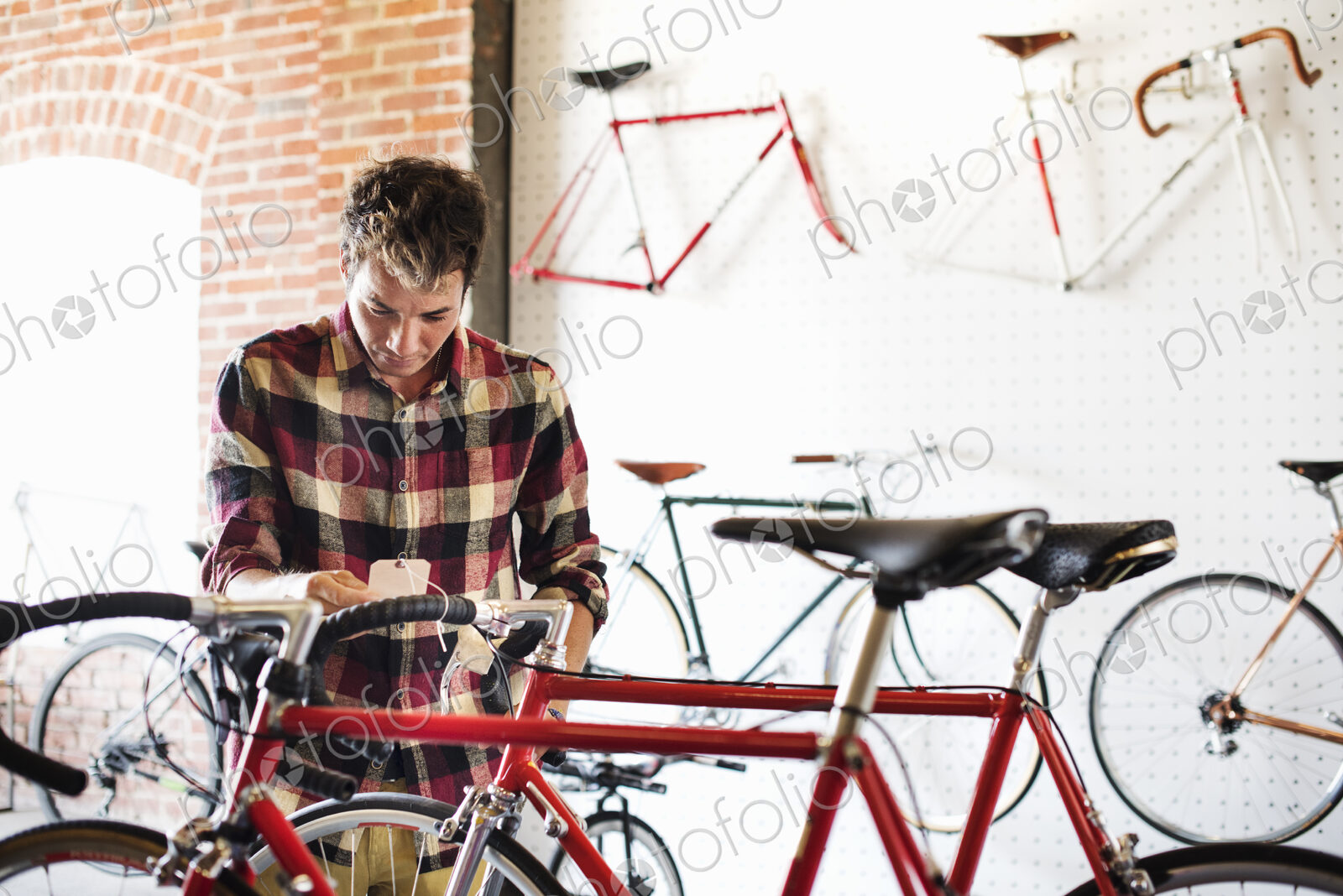 A man in a cycle shop, reading the price label on a bike.