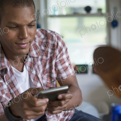 A man in a kitchen, using a digital tablet. A man in a kitchen, using a digital tablet.