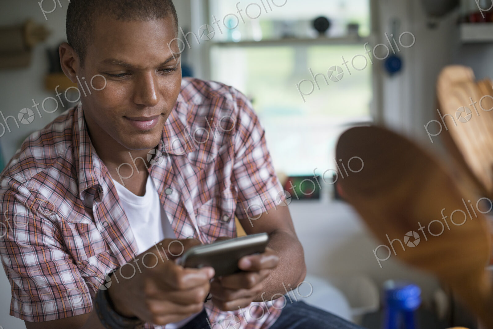 A man in a kitchen, using a digital tablet.