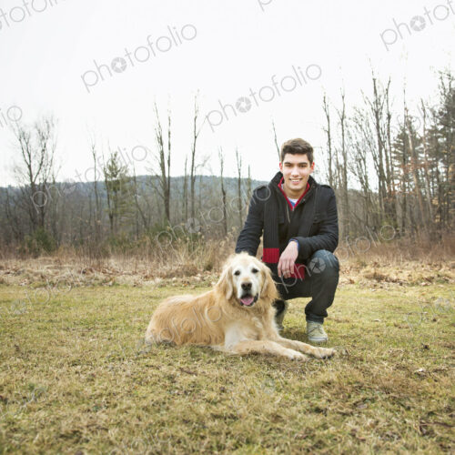 A man in the open air, on a winter day. Stroking a golden retriever dog. A man in the open air, on a winter day. Stroking a golden retriever dog.