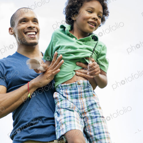 A man lifting his son up in his arms, playing outdoors. A man lifting his son up in his arms, playing outdoors.
