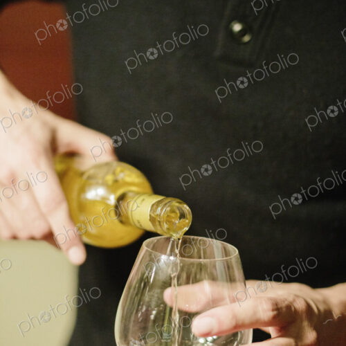 A man pouring a glass of spirits into a glass. A man pouring a glass of spirits into a glass.
