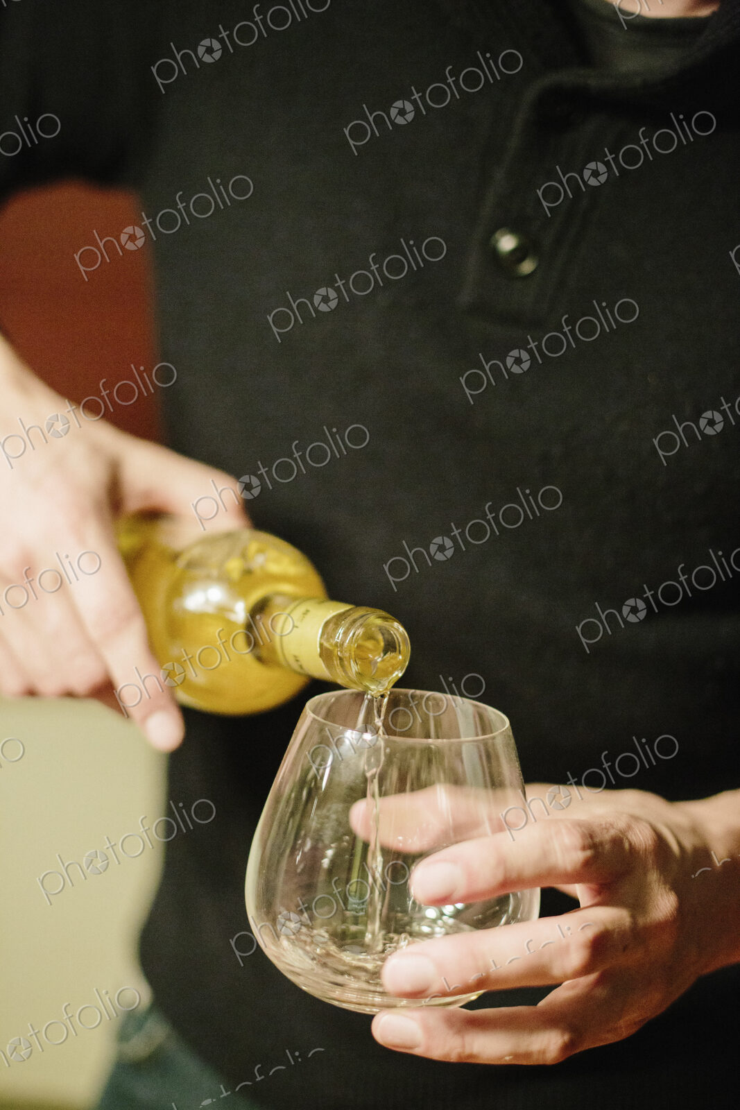 A man pouring a glass of spirits into a glass.