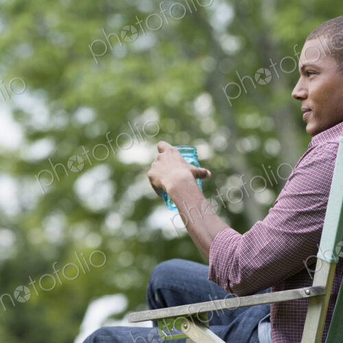 A man seated in a chair in a garden, relaxing. A man seated in a chair in a garden, relaxing.