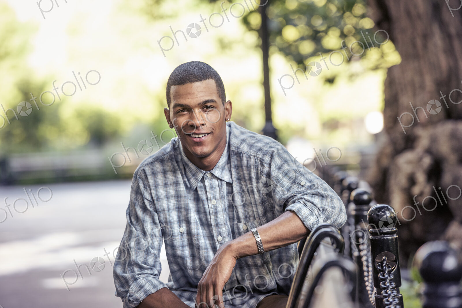 A man seated in a city park relaxing on a bench