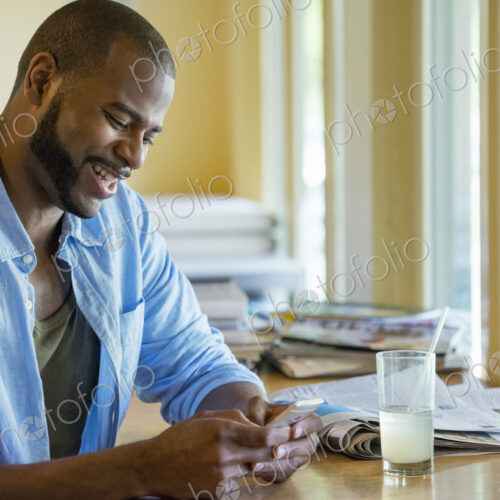 A man sitting alone in a cafe, using his smart phone. A man sitting alone in a cafe, using his smart phone.