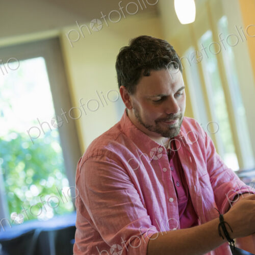 A man sitting at a cafe table, using a smart phone. A man sitting at a cafe table, using a smart phone.