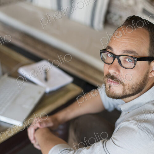 A man sitting at a desk using a laptop computer. Running a small business.